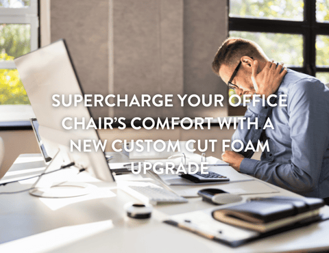 person sitting at office desk on an office chair holding his neck in pain