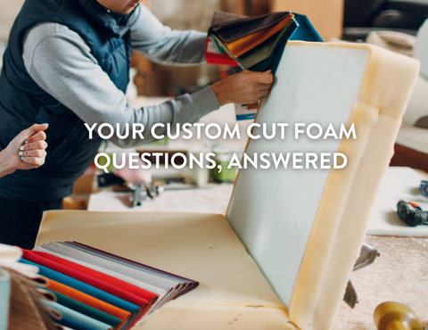 Two people discussing fabric samples next to a large piece of custom cut foam. 